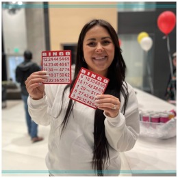 Love where you live a person smiling holding up bingo cards