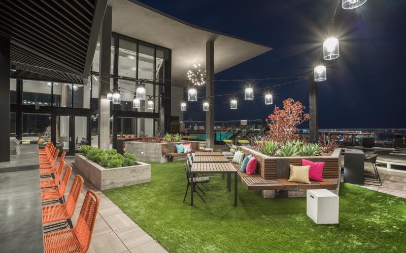 a rooftop lounge with chairs and a table