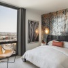 a bedroom with a chair, bed and large window