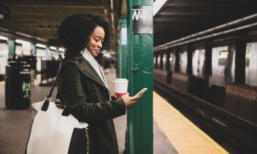 Find your perfect fit at Shift woman with a cup of coffee texts on subway station platform